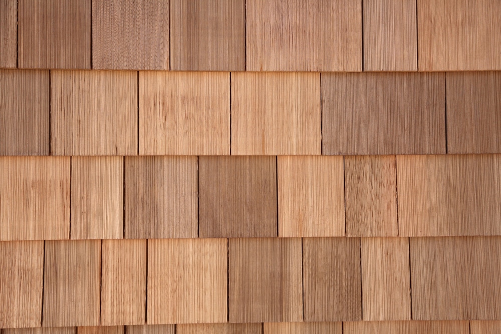 A close-up view of wooden shingles arranged in neat, horizontal rows, showcasing natural wood grain and varying shades of brown—an ideal example for any home improvement Suffolk County, NY project.